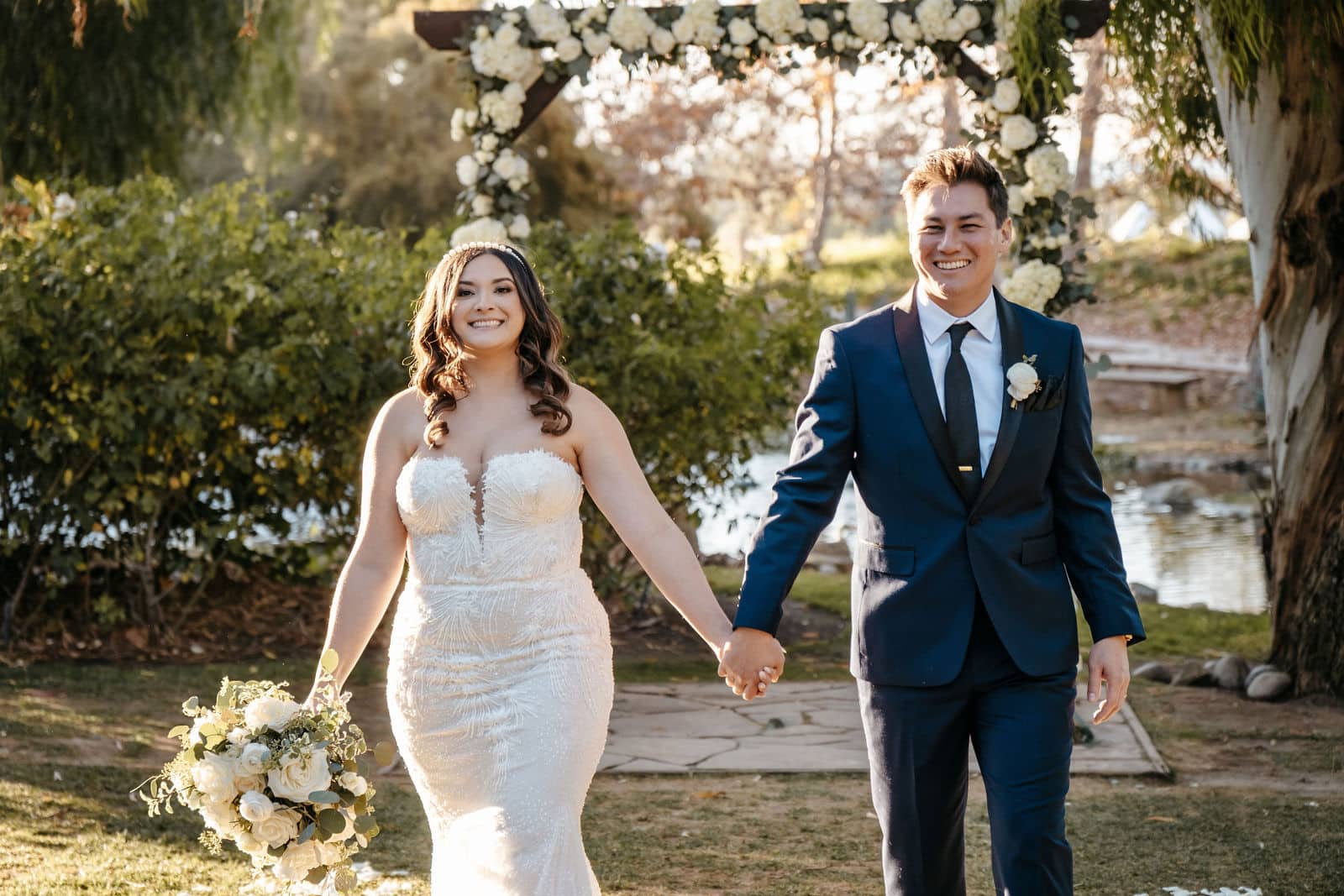 bride and groom holding hands wearing beautiful smile