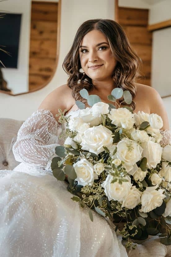 beautiful bride holding white rose bouquet